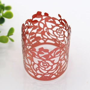 Close-up of red laser-cut paper napkin ring with intricate floral rose patterns