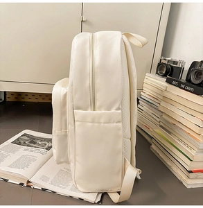 Side view of cream white casual backpack showing side pocket and breathable mesh back padding