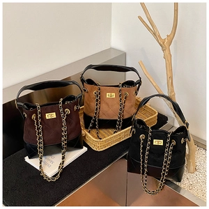 Three vintage quilted bucket bags in brown and black with golden chain straps and clasps