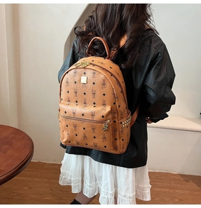 Brown monogram backpack detail featuring gold-tone logo plate and studded side pocket