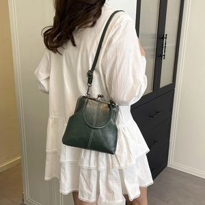 Retro dark green shell-shaped doctor bag with vintage metal clasp and top handle