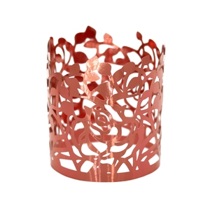 Detailed close-up of rose gold metal napkin ring featuring laser-cut floral patterns