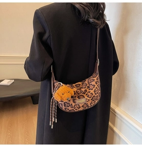 Detailed shot of leopard print hobo bag with teddy charm and brown leather strap