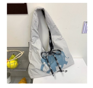 Detail of grey tote bag featuring blue elephant print and black-white checkered bow
