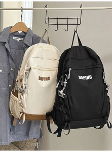 Detail view of large-capacity sports backpacks in beige and black with side buckles