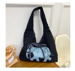 Close-up of black canvas tote bag featuring blue elephant print and blue plaid bow detail