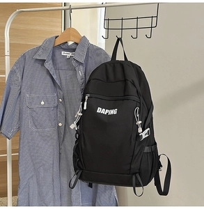 Detail view of durable black backpack with white logo and decorative zipper paracord