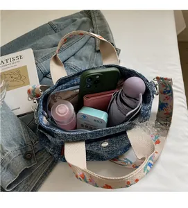Detail view of denim tote bag interior showing large capacity for phone and wallet