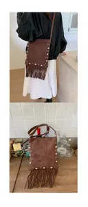 Detailed close-up of brown suede crossbody bag with metal rivets and long fringe tassels