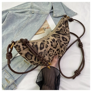 Dettaglio ravvicinato della borsa croissant leopardata con tracolla regolabile e nodi