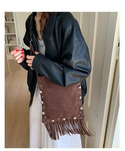 Detailed view of dark brown suede fringe bag with silver studs and bohemian tassels