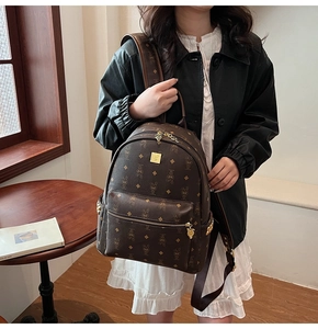 Close-up of brown synthetic leather backpack with cartoon rabbit print and gold plaque