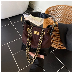 Detail of vintage tote bag with brown suede and black quilted leather with chain