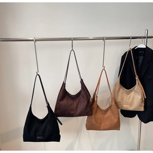Dettaglio di quattro grandi borse tote minimaliste in pelle scamosciata in vari colori