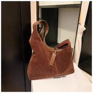 Détail d'un grand sac cabas en daim marron foncé au design hobo rétro avec étiquette pendante