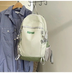 Detail of light green waterproof nylon backpack with multiple zipper pockets and buckles