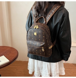 Detail of brown leather backpack with rabbit print and golden rivet decorations