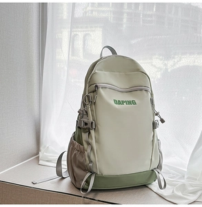 Detail of green travel backpack with DAPING logo, grey webbing, and plastic buckle
