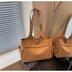 Dettaglio della borsa tote in tela marrone con tasche funzionali e dettagli con cerniera