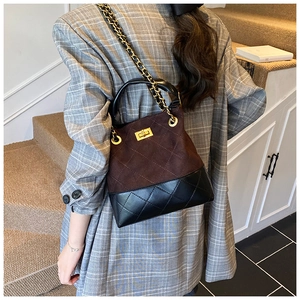 Detail of vintage bucket bag with brown suede and black quilted leather with chain