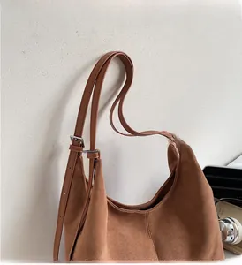 Dettaglio borsa tote in pelle scamosciata marrone con tracolla e cuciture salde
