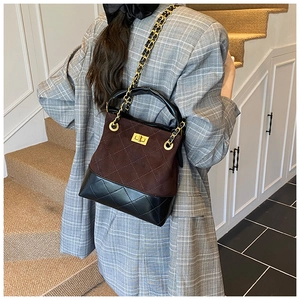Detail of color-block quilted shoulder bag with gold chain and metal twist lock