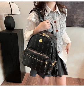 Detail of black cartoon pattern backpack with gold hardware and decorative studs