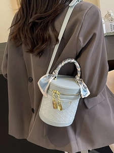 Light blue bucket bag with woven texture and floral scarf handle for elegant fashion