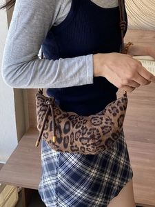 Borsa a mezzaluna leopardata con trama felpata e tracolla in pelle su una modella