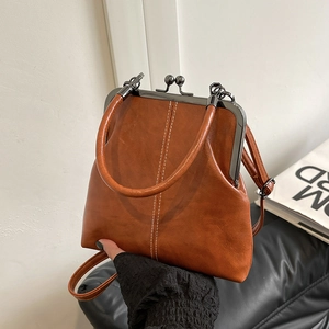 Detailed view of caramel brown retro shell bag with leather texture and kiss-lock closure