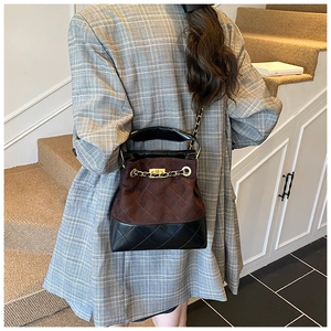 Detail view of contrast vintage bucket bag with brown suede and black quilted leather