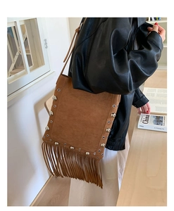 Detail view of brown matte suede shoulder bag with long fringe and silver rivet studs