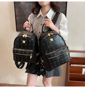 Comparison of two sizes of black monogrammed backpacks with golden zipper hardware