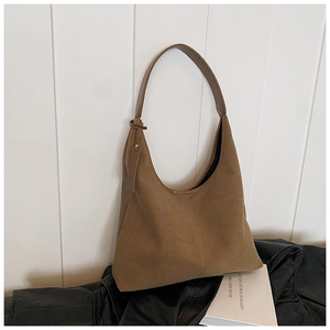 Détail d'un sac hobo en daim marron avec intérieur spacieux et étiquette décorative