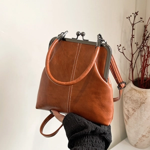 Detail of vintage brown shell bag with white stitching and gunmetal clasp hardware
