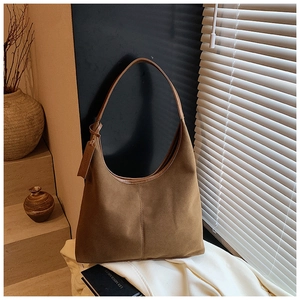 Gros plan détaillé d'un grand sac cabas en daim marron avec des coutures verticales précises