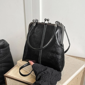 Detailed close-up of a vintage black shell crossbody bag with smooth leather texture