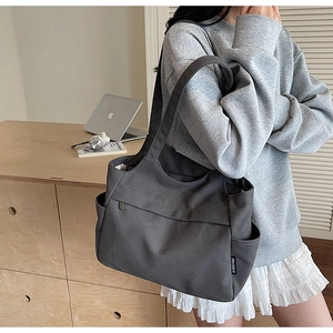 Dettaglio di una borsa tote grande in tela grigia con tasche e tracolla resistente
