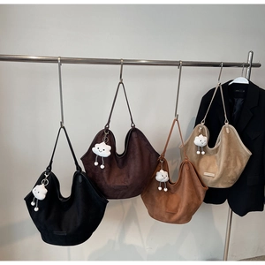 Detail of four colorful suede tote bags with Fashion & Bag labels and cloud charms