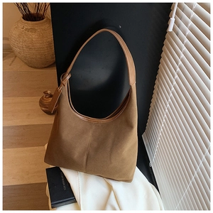 Détail du sac cabas en daim marron avec garniture en cuir et forme de croissant au naturel