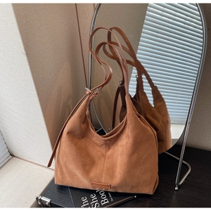 Dettaglio della borsa tote in pelle scamosciata marrone con tracolla regolabile