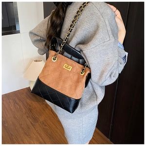Detail of retro contrast bucket bag with quilted suede, chain strap and gold hardware