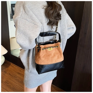 Detail of vintage contrast bucket bag with suede texture and gold twist-lock closure