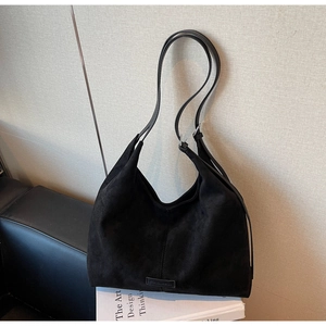 Dettaglio della grande borsa tote in pelle scamosciata nera con tracolla e logo