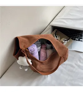 Detail shot showing the large capacity of the brown suede tote bag with daily items inside