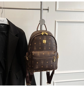 Detail of coffee brown mini backpack featuring rabbit print and gold metal logo plaque