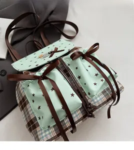 Detail of blue plaid backpack with mint green pockets and brown ribbon bow accents