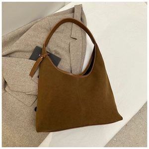 Détail du sac hobo en daim marron café avec coutures et bandoulière en cuir souple
