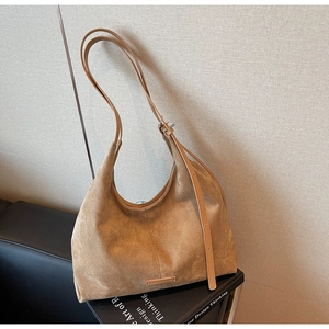 Dettaglio della borsa hobo in pelle scamosciata marrone con tracolla regolabile vintage