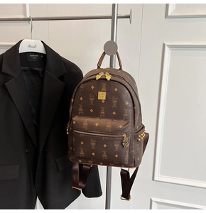 Detail of brown faux leather backpack with cartoon rabbit monogram and gold rivets